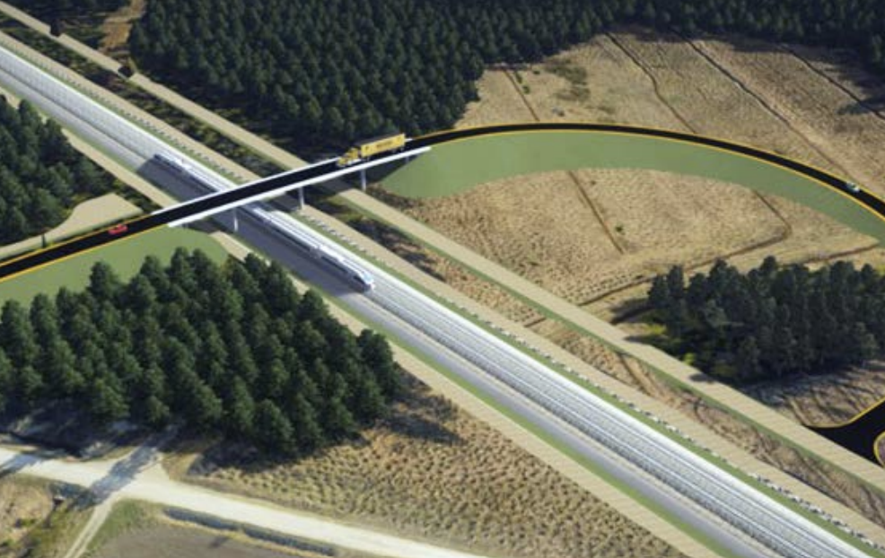 Aerial view of a wildlife bridge over a highway in Latvia, with trees on one side and open land on the other, connecting habitats for safe animal crossings.