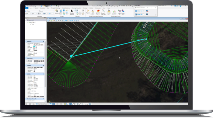 A laptop displaying OpenSite Designer with green wireframe models and a dark background.