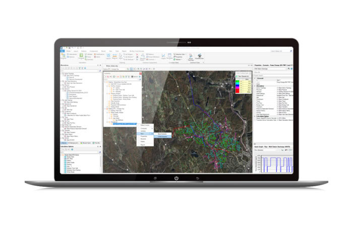 A laptop screen displaying GIS software with a detailed map and various analytical tools and data layers panel.