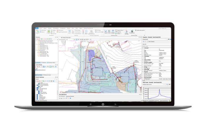 A laptop screen displays a detailed software interface featuring geographical mapping and data analysis tools.