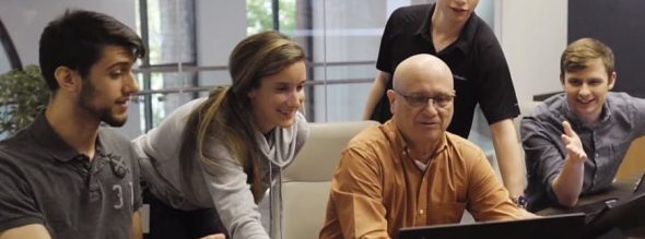 A group of individuals looking at a laptop