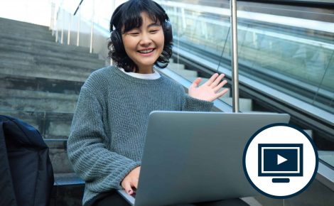 A person with headphones sits on stairs, uses a laptop, and waves, suggesting a video call. An icon of a computer screen is overlaid on the right side, indicating an online learning session.