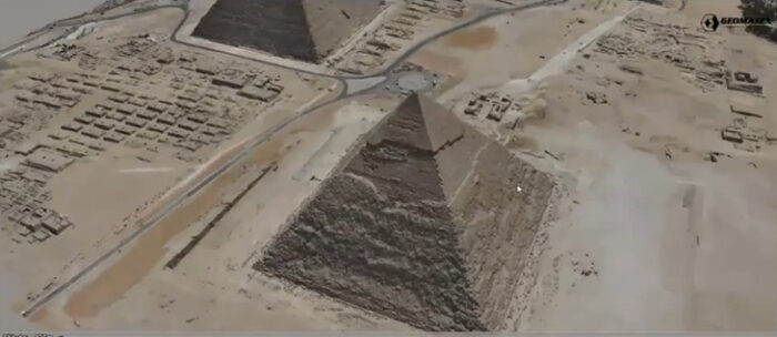 Aerial view of the Giza pyramids in Egypt showcases two majestic pyramids surrounded by vast desert terrain. Nearby roads and smaller structures dot the landscape, as if participating in an exclusive Partner Spotlight.
