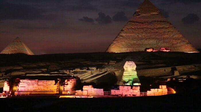 The Pyramids and Sphinx at Giza come alive under the dark evening sky, a dazzling Partner Spotlight for Geomatex as they illuminate these ancient wonders with vibrant, colorful lights.