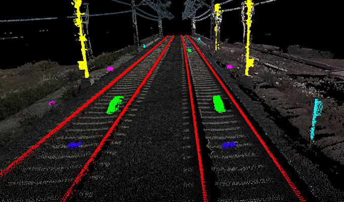 Lidar image of a railway track with neon-colored outlines and points, highlighting yellow poles, red tracks, and various colored markers.
