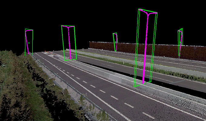 A digital rendering of a highway with green and pink rectangular overlays on poles, depicting a nighttime scene with clear lanes and surrounding vegetation.