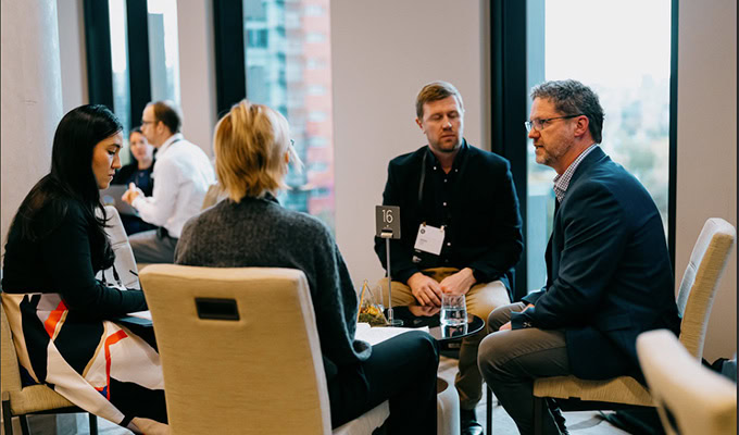 Photo of a two men and two women meeting seated around a table