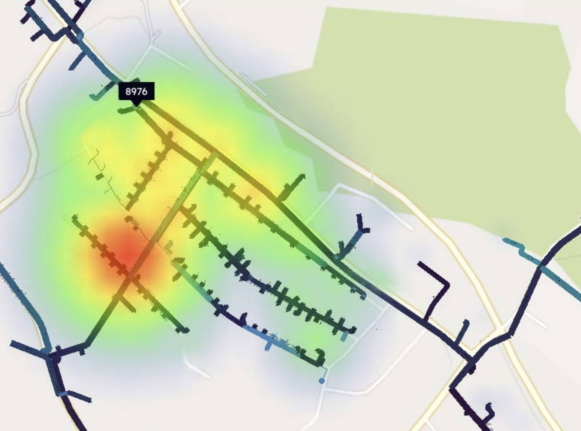 A map displaying a heatmap overlay with color gradients ranging from green to red, indicating varying levels of data concentration in an area with a label marked "8976," employs Intelligent Digital Optimization for enhanced precision.