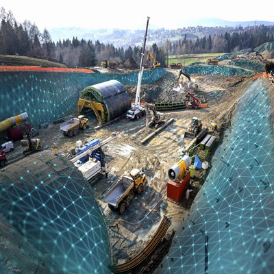 The construction site, featuring various heavy machinery such as excavators, trucks, and cranes in operation, is marked with a patterned overlay indicating possible planning or mapping activity by CMW Geosciences.