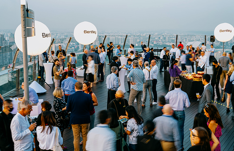 Outdoor corporate event with attendees networking on a rooftop.