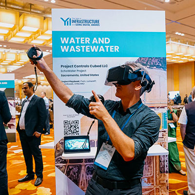 A man wearing a virtual reality headset at a water and wastewater infrastructure conference booth.