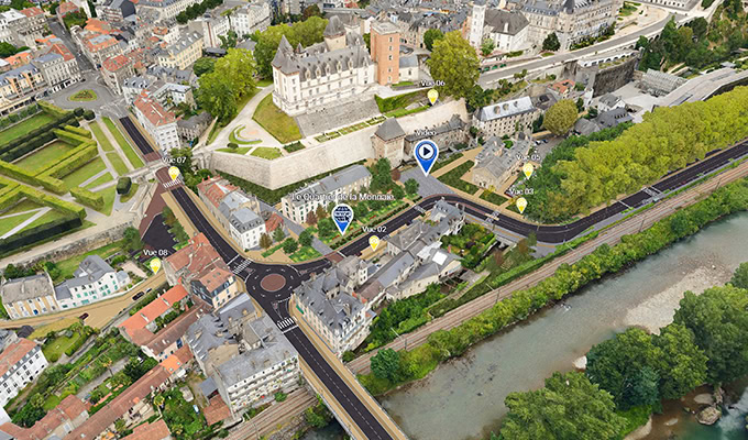 Aerial view of a town with historic buildings, a river, and green spaces. Markers indicate key locations on the map.