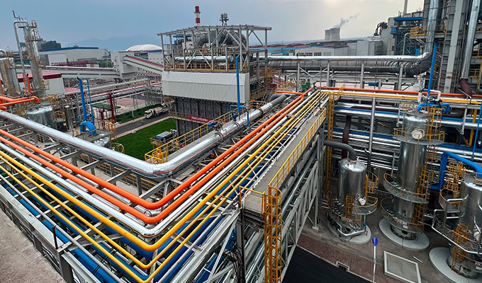 An industrial facility with extensive pipes, tanks, and machinery, including colorful pipelines, metal structures, and storage units, exemplifying modern industrial engineering.