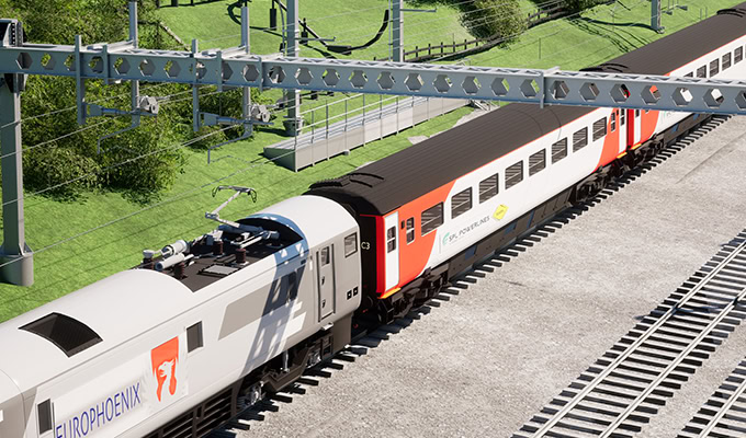 A modern passenger train with white and orange carriages travels along a railway track, surrounded by greenery and overhead power lines.