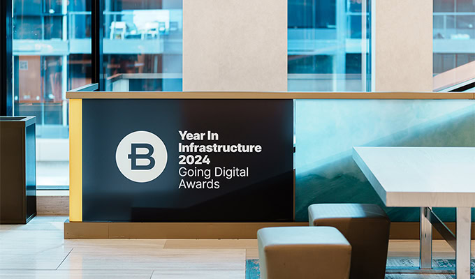 Placa com o logotipo do Year In Infrastructure e Going Digital Awards 2024 na lateral da escada